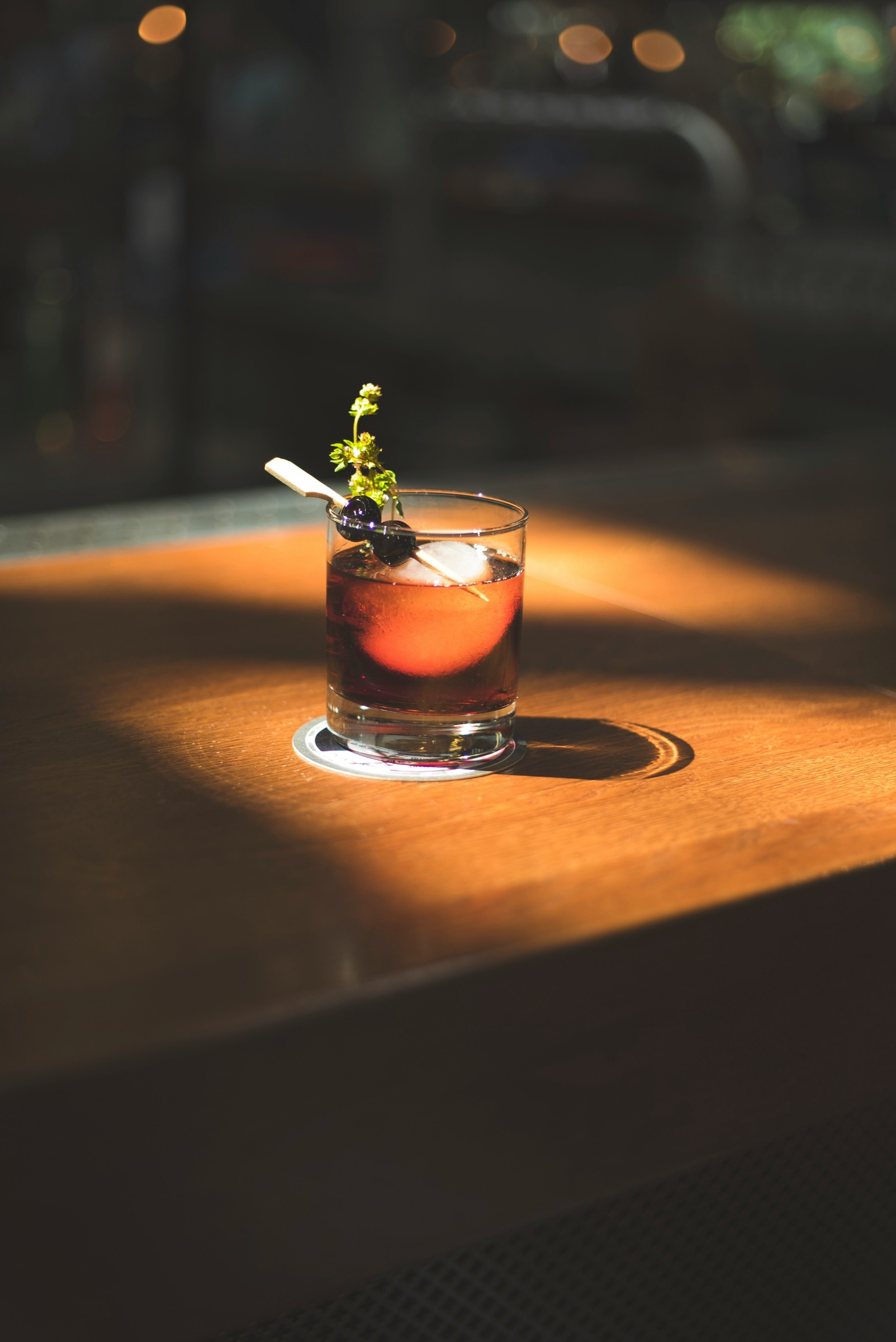 A signature cocktail glowing in warm bar light